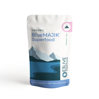 A close-up view of a pouch containing 50g of Blue Majik® dietary supplement powder. The label on the pouch shows the product name, and the powder is a vibrant blue in color.