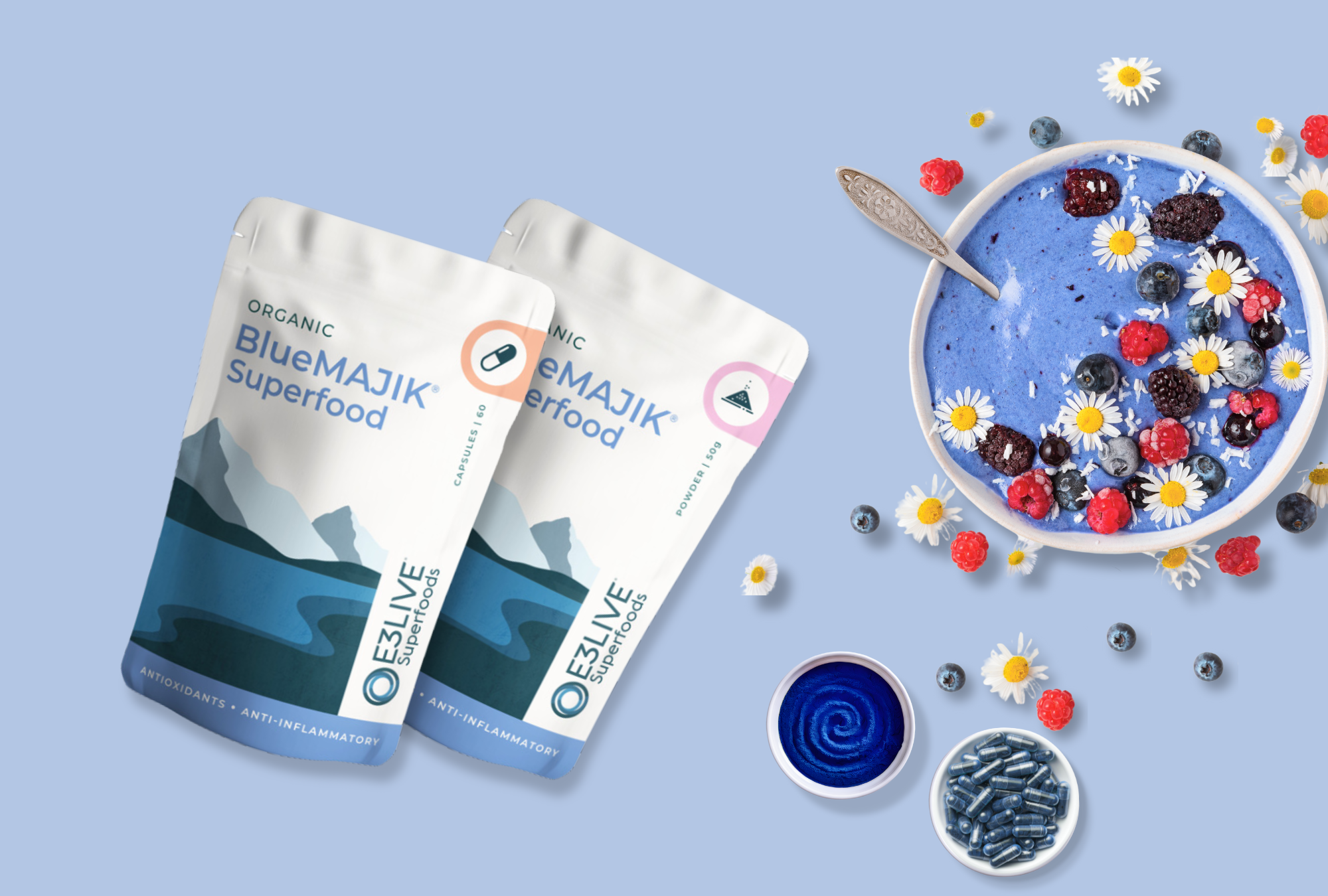 BlueMAJIK Superfood products, including powder and capsule forms, displayed alongside a vibrant blue smoothie bowl topped with berries, chamomile flowers, and coconut shavings on a light blue background. This image showcases BlueMAJIK's antioxidant and anti-inflammatory benefits, emphasizing its role in supporting wellness and vitality.