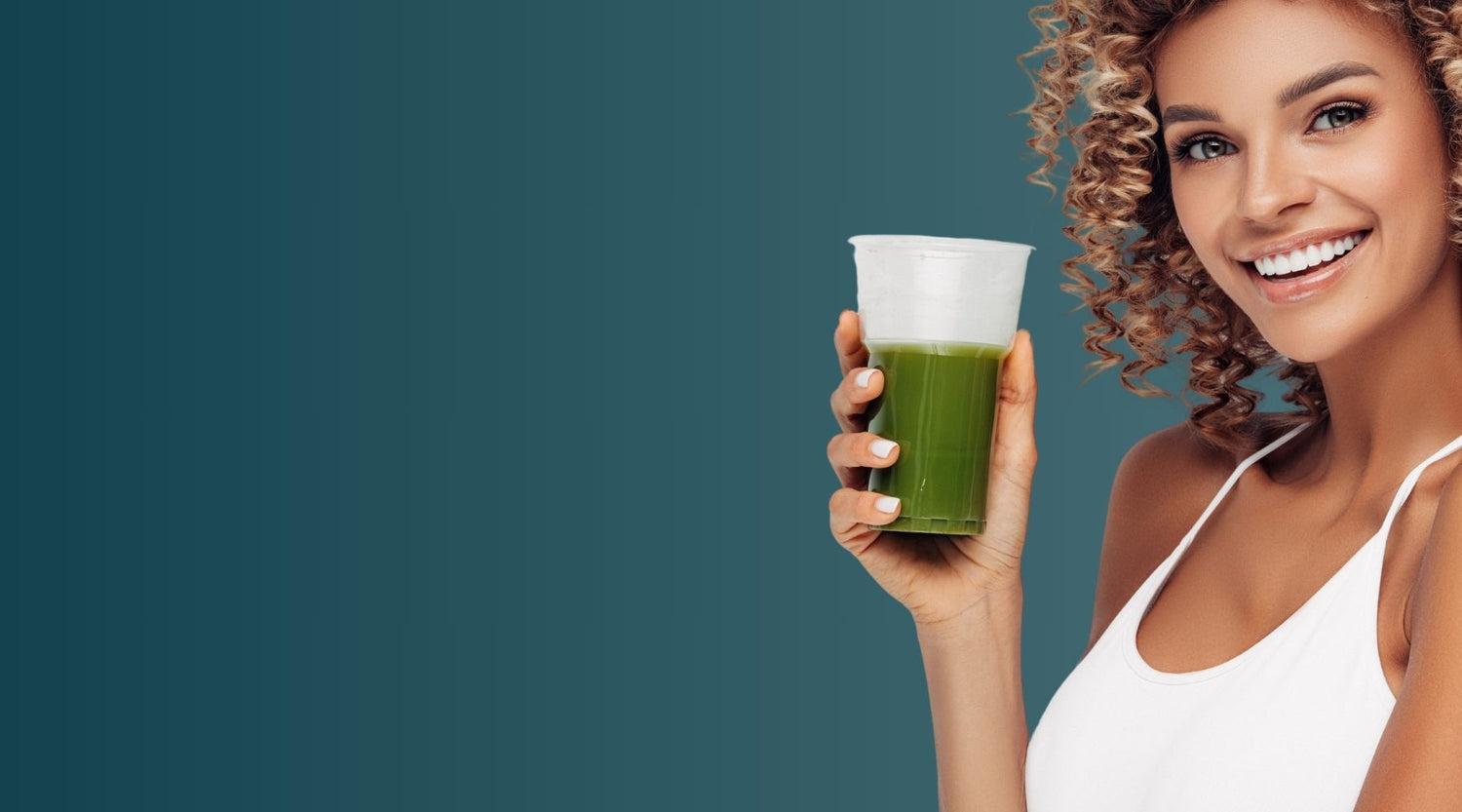 Smiling woman holding a green superfood drink, representing a wide range of E3Live Superfoods products focused on health, energy, and wellness.